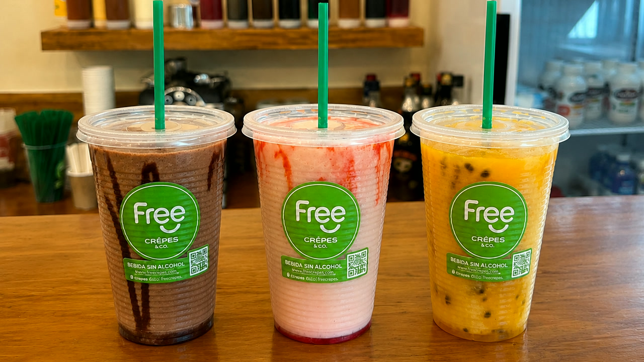 Tres licuados en vasos Free Crepes sobre el mostrador